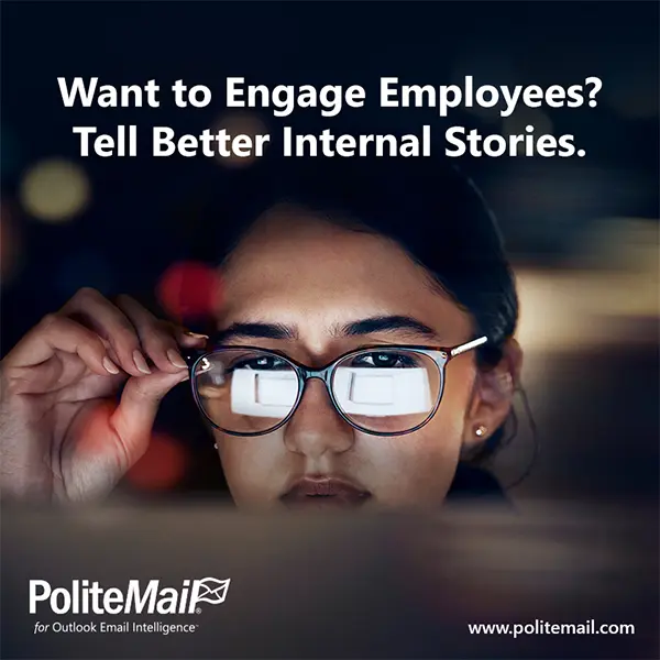 An image of a young female office worker looking at a laptop with the screen reflected in her glasses.